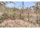 An iron gate with wood posts leads to a wooded area on the property at 135 Rapture Ln, Wando, SC 29492