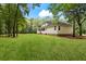 Side view of a light yellow two-story home showcasing a large, well-manicured lawn and surrounded by mature trees at 140 Old Plantation Ln, Moncks Corner, SC 29461