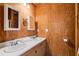 Bathroom featuring double sinks, a large mirror, and wood-paneled walls at 140 Old Plantation Ln, Moncks Corner, SC 29461