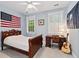 A patriotic bedroom with a bed, desk, and guitar at 140 Old Plantation Ln, Moncks Corner, SC 29461