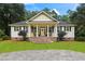 Charming single-story home featuring a cozy front porch with rocking chairs and well-manicured landscaping at 140 Old Plantation Ln, Moncks Corner, SC 29461