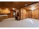 Cozy living room with kitchenette, wood paneling, carpet, and plenty of open space at 140 Old Plantation Ln, Moncks Corner, SC 29461
