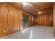 Spacious living room with wood-paneled walls, ceiling fan, and glass door to the outdoors at 140 Old Plantation Ln, Moncks Corner, SC 29461