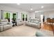 Spacious living area with comfortable seating, a ceiling fan, and access to the outdoors through double doors at 140 Old Plantation Ln, Moncks Corner, SC 29461
