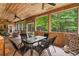 Spacious screened porch featuring a dining table, seating, and beautiful views of the surrounding trees at 140 Old Plantation Ln, Moncks Corner, SC 29461