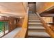 Carpeted staircase showing access to upper and lower levels, and the wood paneled living area at 140 Old Plantation Ln, Moncks Corner, SC 29461