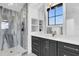 Modern bathroom with glass shower, stone tile, gray vanity, and light countertops at 151 Brailsford St, Charleston, SC 29492