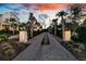 Elegant driveway lined with palm trees leads to a luxurious estate at twilight at 151 Brailsford St, Charleston, SC 29492