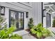 Exterior door with black trim is surrounded by greenery and decorative lighting fixtures at 151 Brailsford St, Charleston, SC 29492