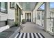 Inviting front porch with elegant seating and stylish black and white striped rug at 151 Brailsford St, Charleston, SC 29492