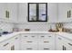 Close-up of upper kitchen cabinets with glass insets and geometric backsplash at 151 Brailsford St, Charleston, SC 29492