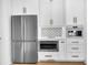 Stainless steel appliances, including a large refrigerator are framed by white cabinets at 151 Brailsford St, Charleston, SC 29492