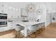 Bright kitchen with white cabinets, quartz countertops, stylish lighting, and seating at the island at 151 Brailsford St, Charleston, SC 29492