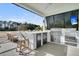Well-equipped outdoor kitchen with bar seating and stainless steel appliances overlooks the lush landscape at 151 Brailsford St, Charleston, SC 29492