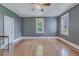 Spacious bedroom with hardwood floors, ceiling fan, two windows, and neutral wall color at 1860 Pinopolis Rd, Pinopolis, SC 29469