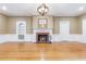 Cozy living room with a beautiful fireplace, hardwood floors, and an elegant light fixture at 1860 Pinopolis Rd, Pinopolis, SC 29469