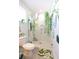 Unique bathroom with a mosaic tiled shower adorned with plants, next to a toilet and leaf patterned rug at 22 1/2 Mary St # A B C, Charleston, SC 29403
