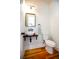 Modern powder room with a vessel sink, stylish fixtures, and wood flooring at 22 1/2 Mary St # A B C, Charleston, SC 29403