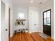 Bright entryway with hardwood floors, coat rack, shoe storage, and a dark wood door, creating a welcoming transition space at 22 1/2 Mary St # A B C, Charleston, SC 29403