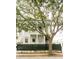 Charming two-story home with a light neutral exterior, featuring a double porch, a green fence, and a beautiful mature tree at 22 1/2 Mary St # A B C, Charleston, SC 29403