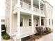 Charming two story home with a balcony, white pillars and muted brown siding at 22 1/2 Mary St # A B C, Charleston, SC 29403