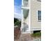 Charming home exterior showcasing light siding, brick steps and an inviting covered porch at 22 1/2 Mary St # A B C, Charleston, SC 29403
