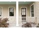 View of the front porch featuring white pillars, and muted brown siding at 22 1/2 Mary St # A B C, Charleston, SC 29403