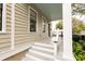 Inviting front porch with white railing and trim, a light blue ceiling, and a classic, well-lit entrance, creating curb appeal at 22 1/2 Mary St # A B C, Charleston, SC 29403