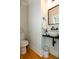 Stylish half-bath featuring modern fixtures, floating sink, and wood flooring at 22 1/2 Mary St # A B C, Charleston, SC 29403
