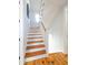 Staircase with wooden stairs and white risers and railings, leading from hardwood to carpet at 22 1/2 Mary St # A B C, Charleston, SC 29403