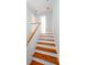 Elegant stairway featuring hardwood steps, a white railing, and abundant natural light, connecting different levels at 22 1/2 Mary St # A B C, Charleston, SC 29403