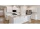 A well-lit kitchen showcases a large island, stainless steel appliances, and white cabinets with wood-look flooring at 287 Blue Haw Dr, Moncks Corner, SC 29461