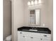 Bathroom vanity with a white cabinet, dark countertop, large mirror, and stylish lighting fixtures at 2932 Old Drake Dr, Seabrook Island, SC 29455