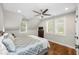 Bright bedroom features hardwood floors, ceiling fan, and two windows with white plantation shutters at 2932 Old Drake Dr, Seabrook Island, SC 29455