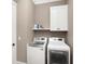 Functional laundry room featuring a side-by-side washer and dryer, along with overhead storage cabinets at 2932 Old Drake Dr, Seabrook Island, SC 29455