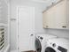 Well-lit laundry room with new washer and dryer and an ample storage cabinet at 2932 Old Drake Dr, Seabrook Island, SC 29455