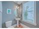 Charming powder room with pedestal sink, oval mirror, and a window for natural light at 3713 Maidstone Dr, Mount Pleasant, SC 29466