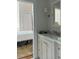 Stylish bathroom with marble countertop, shaker cabinets, wall sconce, and a glimpse into the bedroom at 67 Legare St # 305, Charleston, SC 29401
