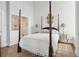 Charming bedroom with a four-poster bed, elegant decor, and ensuite bathroom at 67 Legare St # 305, Charleston, SC 29401