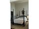 Comfortable bedroom with four-poster bed, ornate mirror, side tables, rug, and closet at 67 Legare St # 305, Charleston, SC 29401