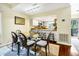 Open concept dining room featuring a glass table, unique chairs, and kitchen view at 796 Summerwind Cir, Edisto Beach, SC 29438