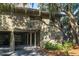 Charming two-story coastal home with covered parking, wooden stairs, and lush landscaping at 796 Summerwind Cir, Edisto Beach, SC 29438