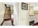 Hallway featuring staircase, hardwood flooring, and a partial view of the kitchen at 796 Summerwind Cir, Edisto Beach, SC 29438