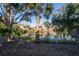 Scenic pond view featuring multiple homes reflected in the water, surrounded by lush greenery and mature trees at 796 Summerwind Cir, Edisto Beach, SC 29438