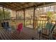 Outdoor dining area with colorful seating, a grill, and a view of the backyard and wooded area at 8020 Nantuckett Ave, North Charleston, SC 29420