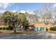 Charming brick home with attached two car garage, manicured landscaping, and mature trees on a sunny day at 8020 Nantuckett Ave, North Charleston, SC 29420