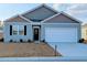 Charming single-story home featuring a two-car garage, manicured lawn, and inviting front door at 911 Woodside Creek Ln, Summerville, SC 29486