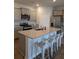 This kitchen features an island with stone countertops, seating, and stainless steel appliances at 911 Woodside Creek Ln, Summerville, SC 29486