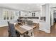 Bright eat-in kitchen features white cabinetry, stainless steel appliances, and a long wooden dining table at 114 Colleton Ave, Summerville, SC 29483