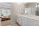 Bright bathroom features a double vanity, a large mirror, and a shower with tiled walls at 116 Snow St, Summerville, SC 29486